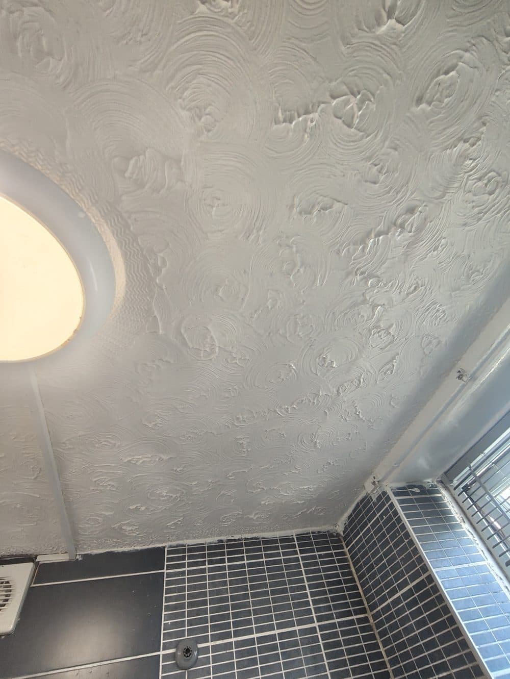 Ceiling after full repaint, swirled texture finish restored with no visible staining