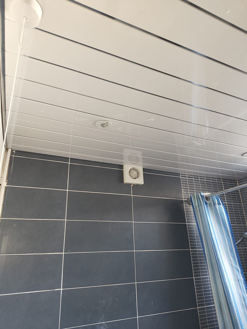 Bathroom ceiling and shower area after full remediation and monitoring period, fully restored and mould-free